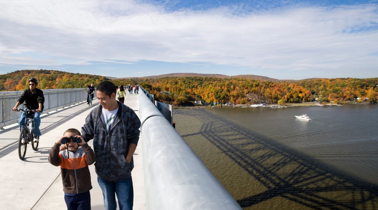 Father and son walk across the Walkway Over the Hudson during autumn