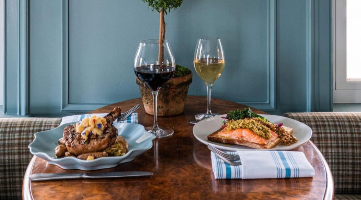 table set with salmon and pork chop dinners at The Vintage Millbrook Inn