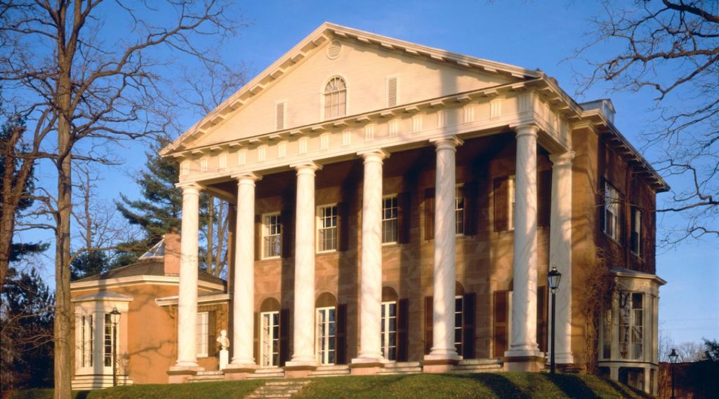 Edgewater in Barrytown, a two-story stone mansion with tall white columns, photographed on a clear, sunny day. Attached photo courtesy of the Richard Hampton Jenrette Foundation, formerly the Classical American Homes Preservation Trust