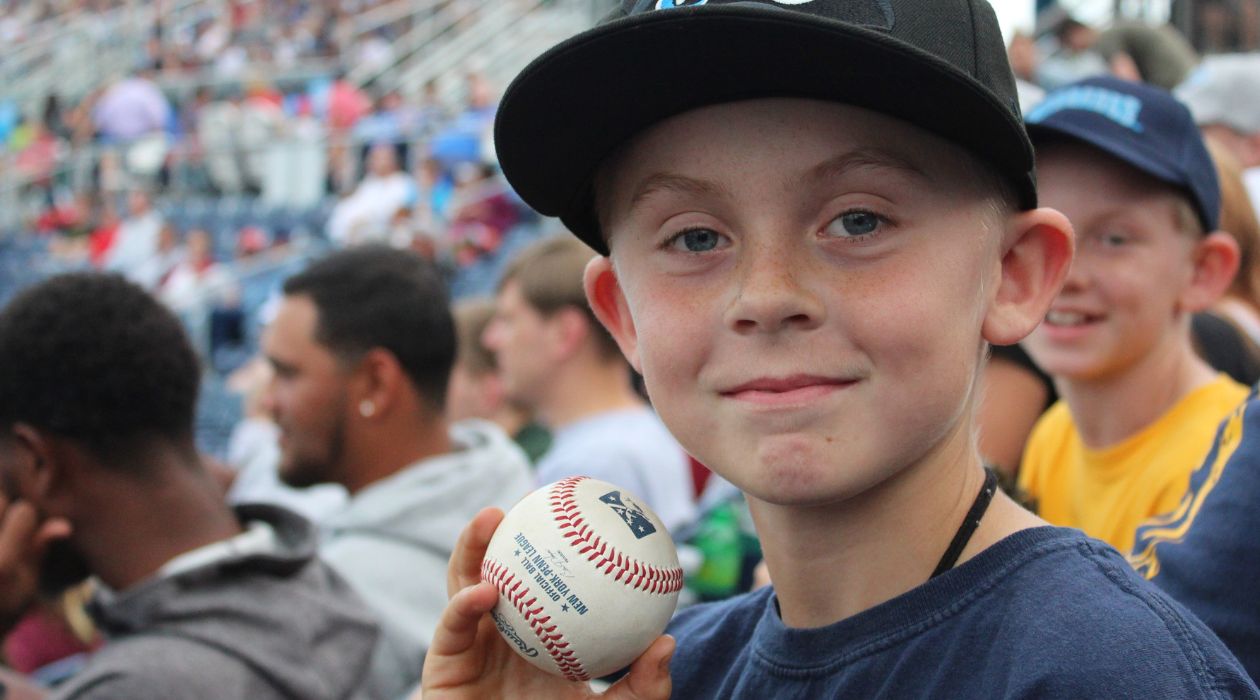 A young baseball fan shows off the souvenir ball he caught at Heritage Financial Park in Wappingers Falls