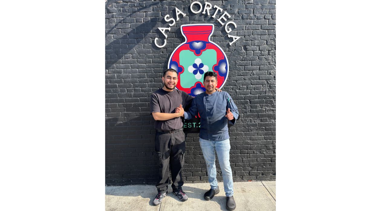 Two men in front of mural Casa Ortega