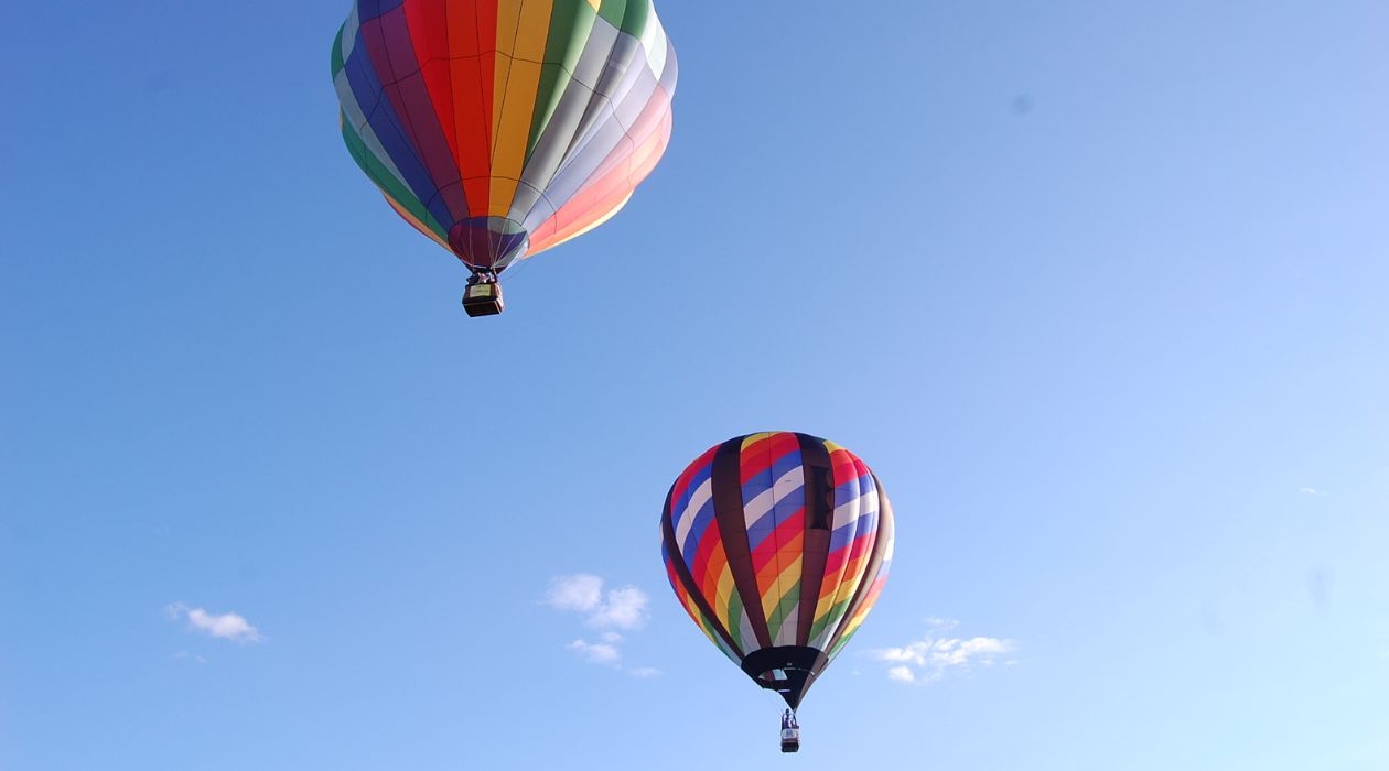 Two hot air balloons flying against a blue sky