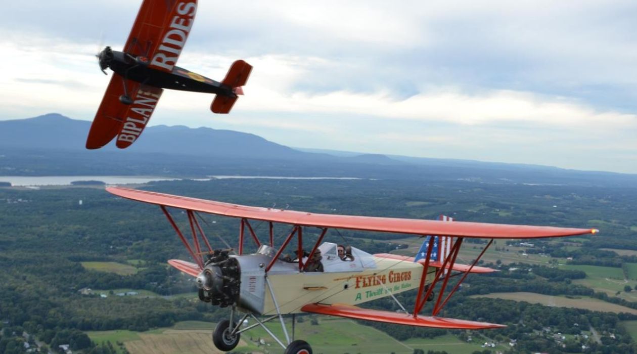 Two WWI replica biplanes flying over the Hudson Valley